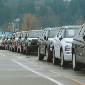 A line of new SUVs parked in an outdoor dealership lot, ready for sale.